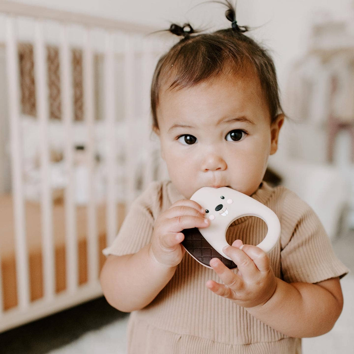 Baby girl using an animal teething toy