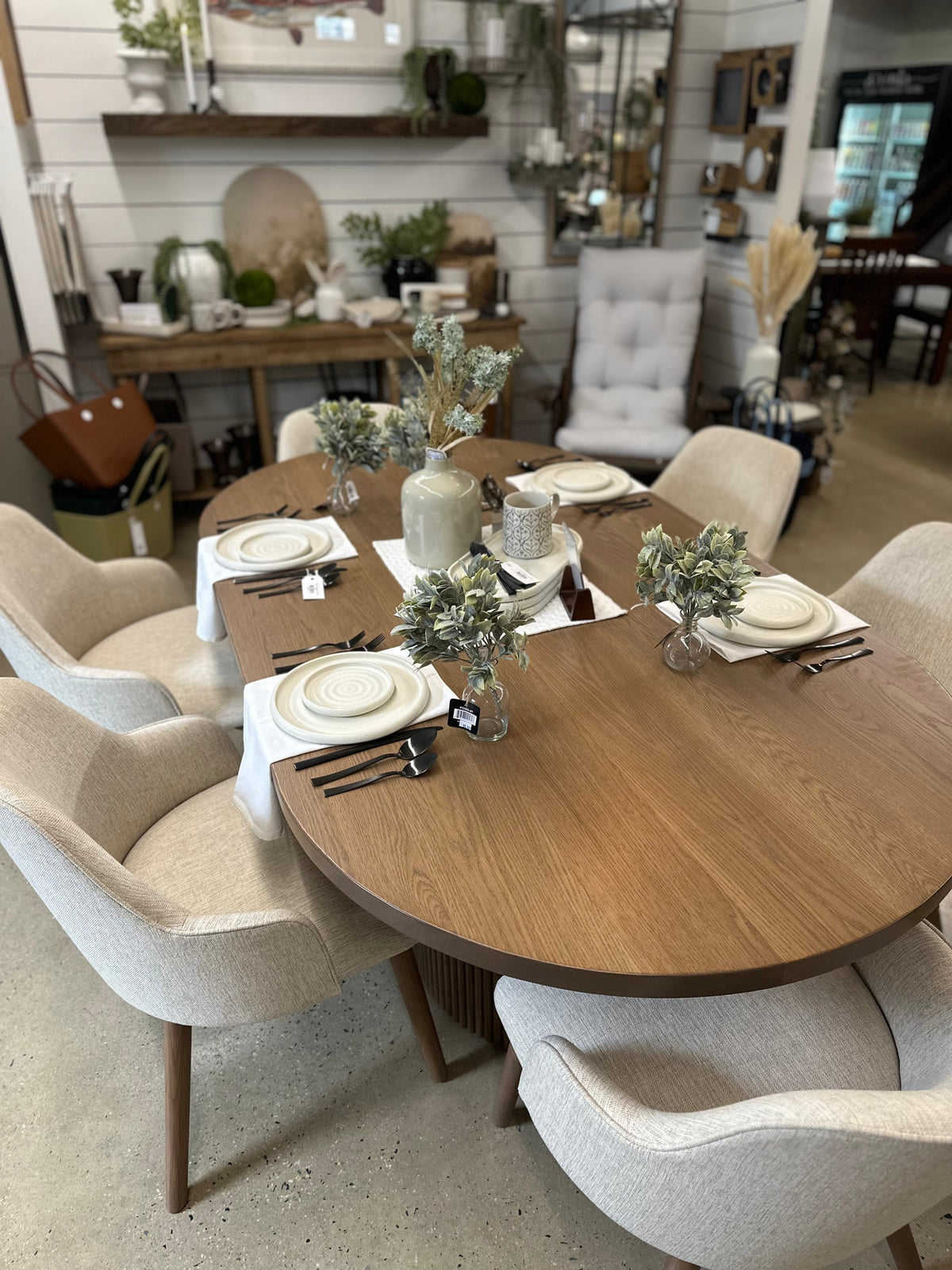 A wooden dining table ready to entertain with four place settings and decorative floral accents.
