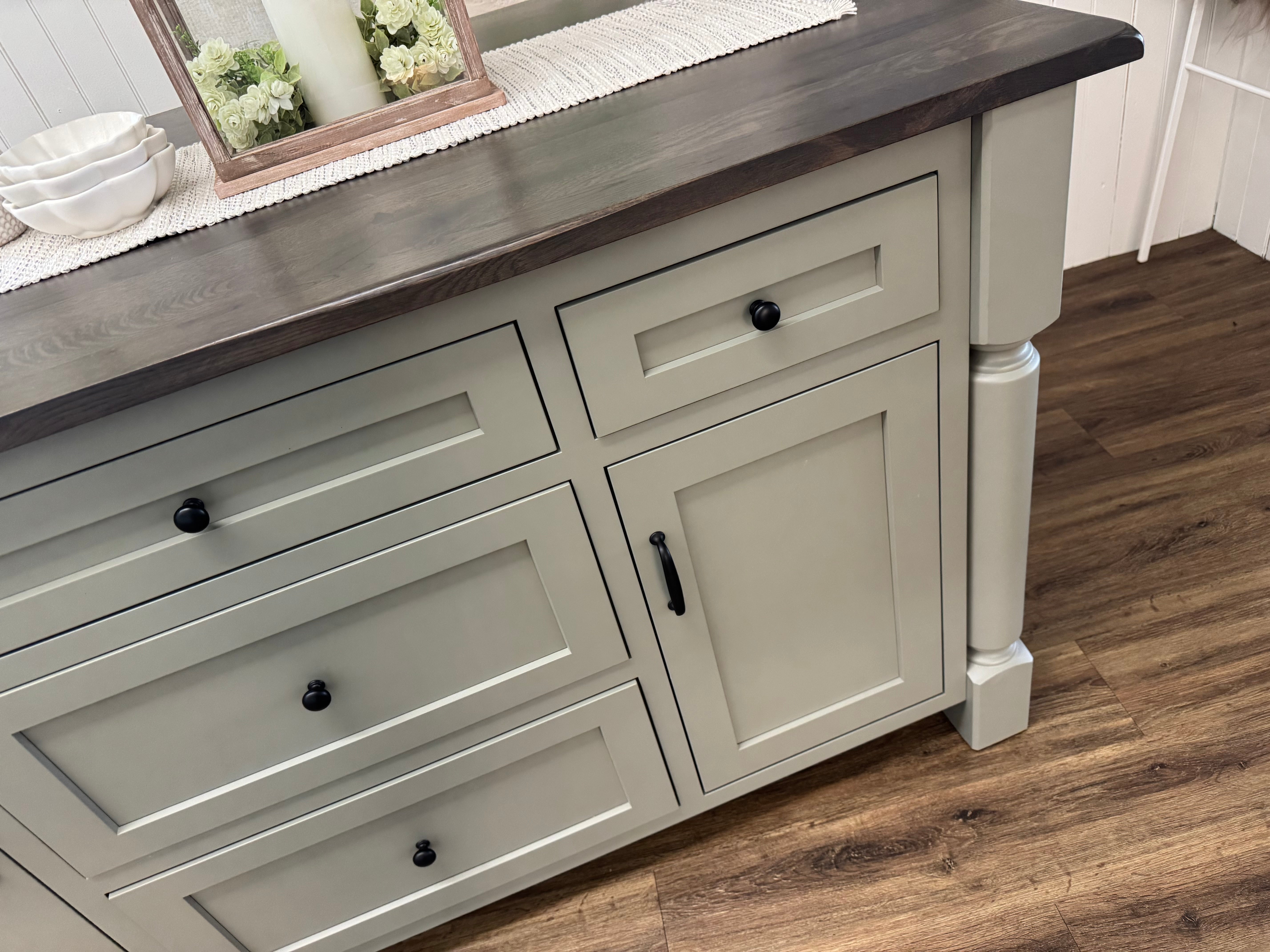 Close up view of an Amish made solid hardwood kitchen island with five drawers and two doors and a slide out table extension on the left side - handcrafted furniture